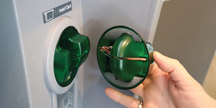 A card skimmer is pulled away from an ATM