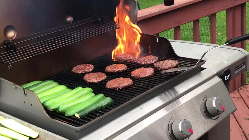 Erik is grilling hamburgers and zucchini